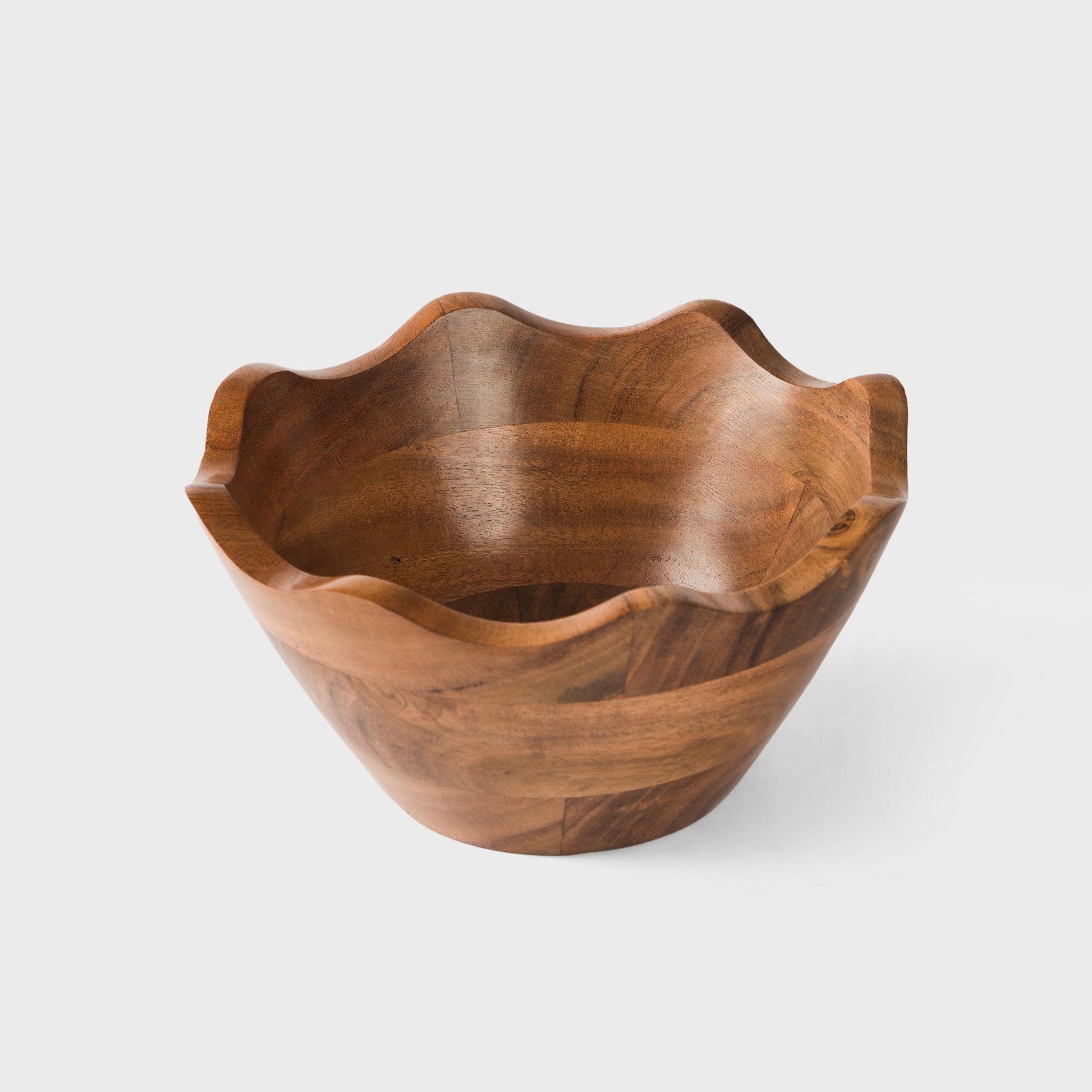 Acacia wood bowl with decorative scalloped rim for modern kitchen styling.