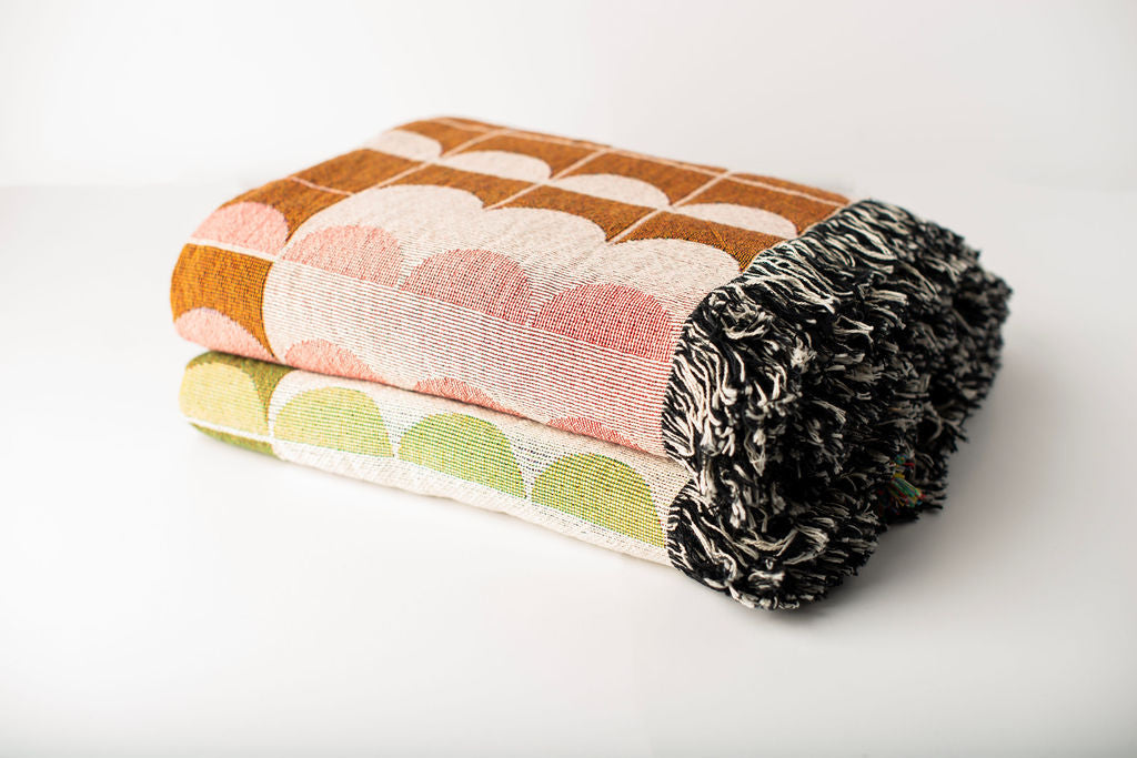 Quinn geometric woven throw blankets stacked in Blush and Meadow colorways