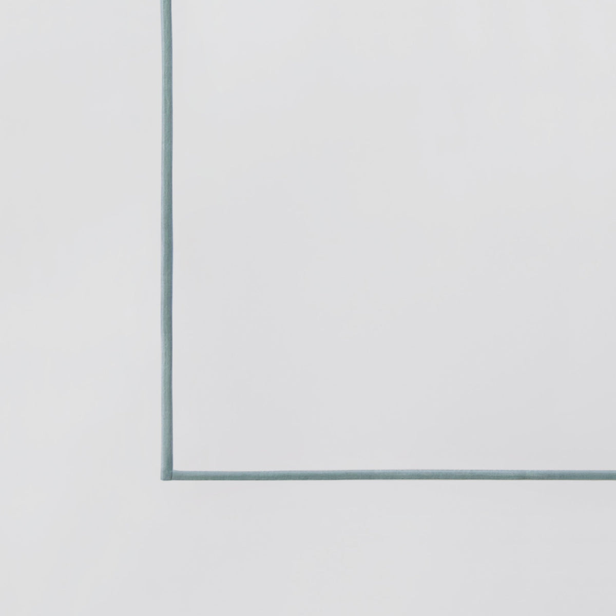 ASP-530-2032_6|Close-up view of a white 100% cotton flat sheet corner with a delicate light blue piped border detail.