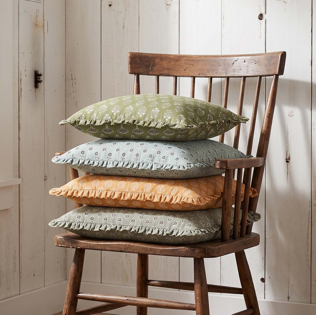 Block-printed ruffled pillows arranged on wooden chair