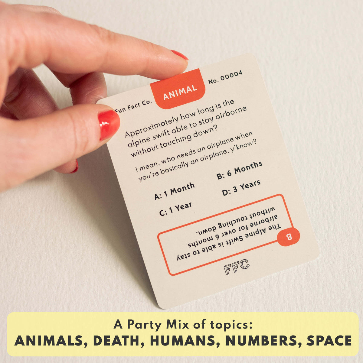 Hand holding a trivia card with multiple-choice questions, featuring the Fun Fact Co. brand.