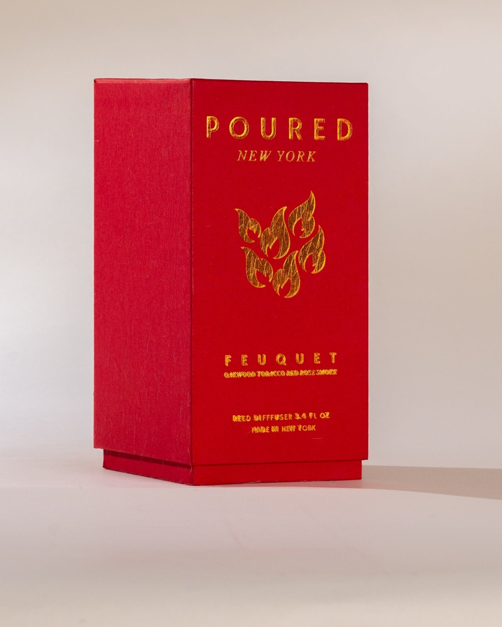 Poured New York ' Feuquet' red reed diffuser  box with a flame decal on a neutral background