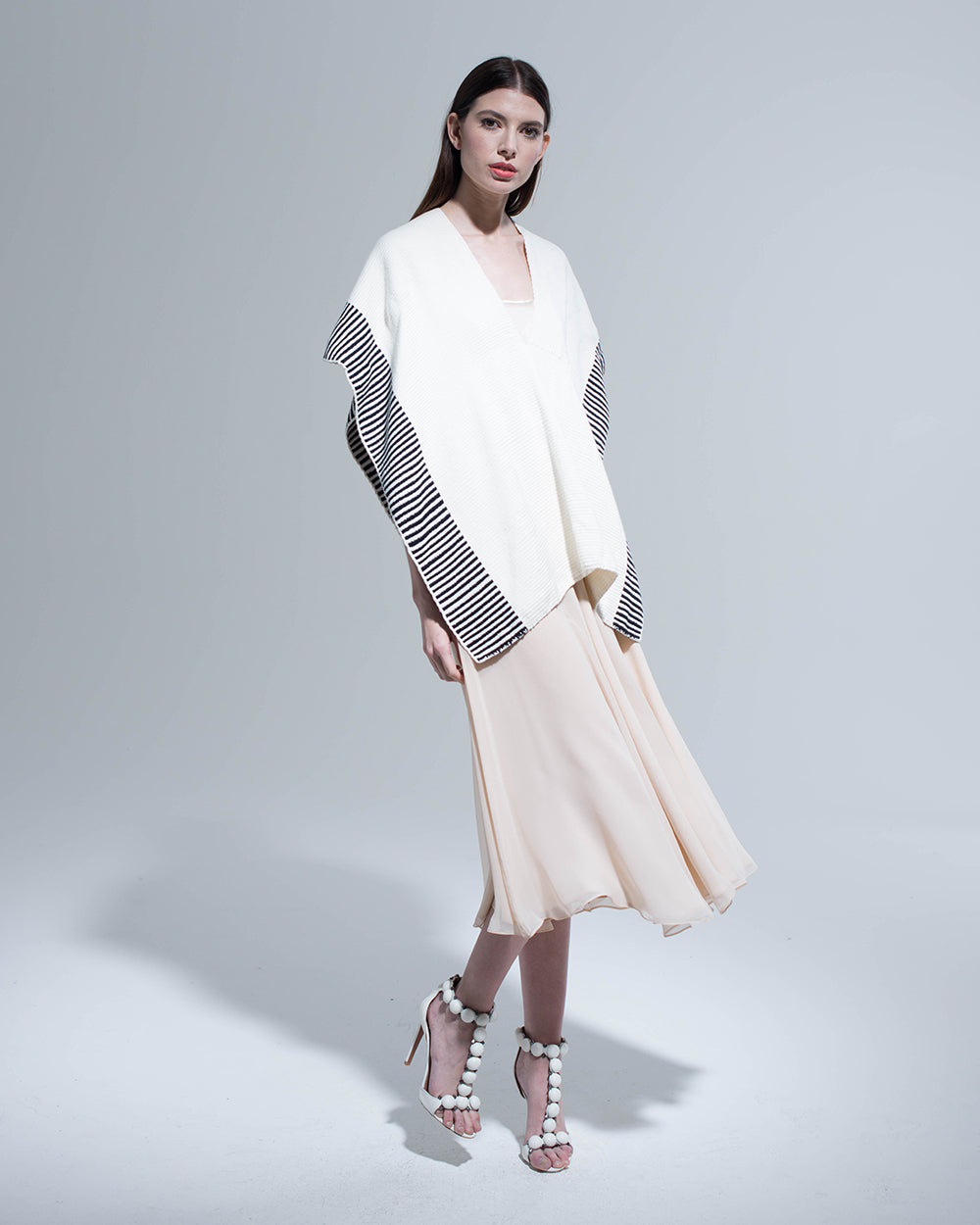 Model wearing an ivory and black striped edge cotton manta over a light dress