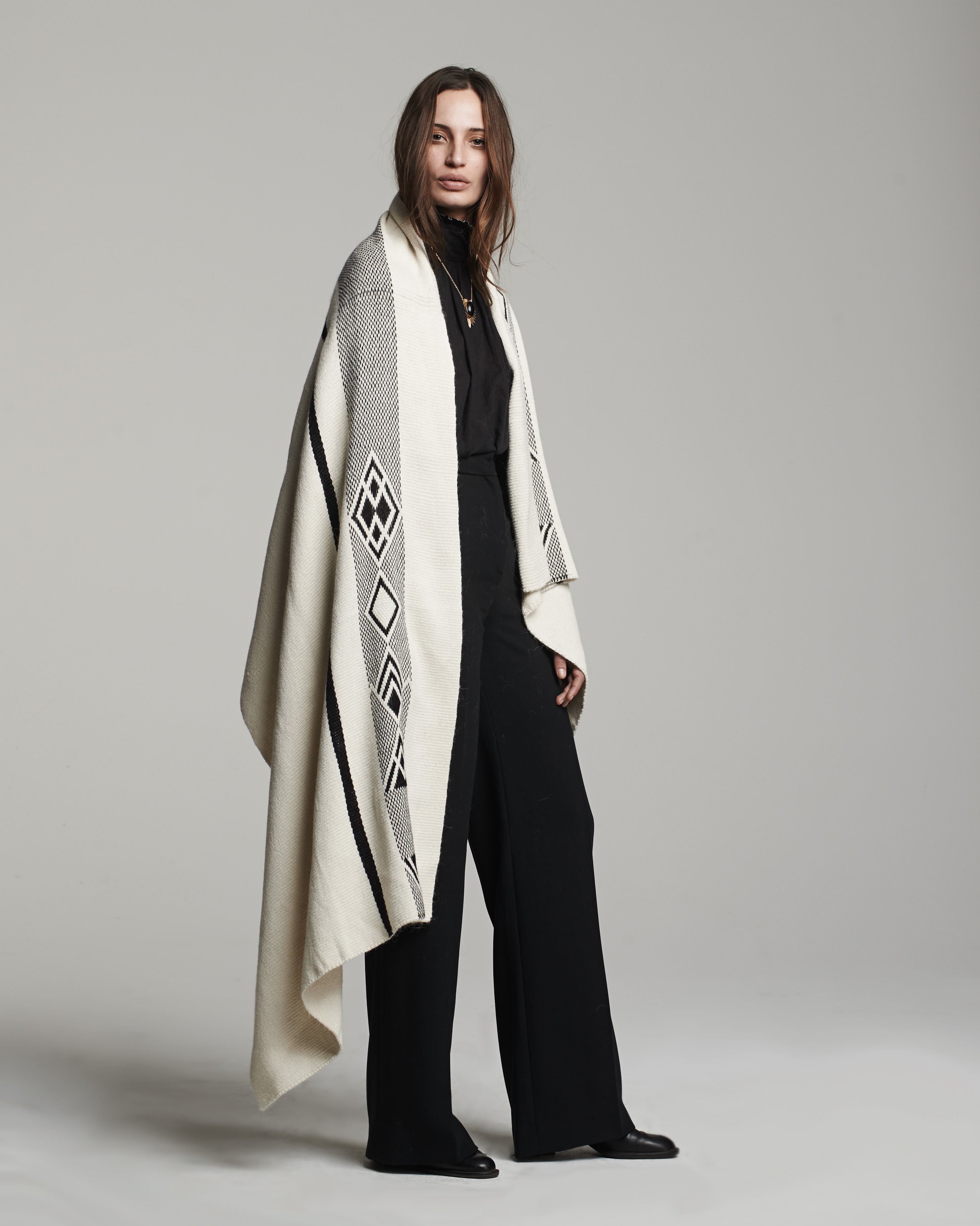 Model wearing a Wide Diagonal Alpaca Wrap in ivory and grey, showcasing its design and texture.