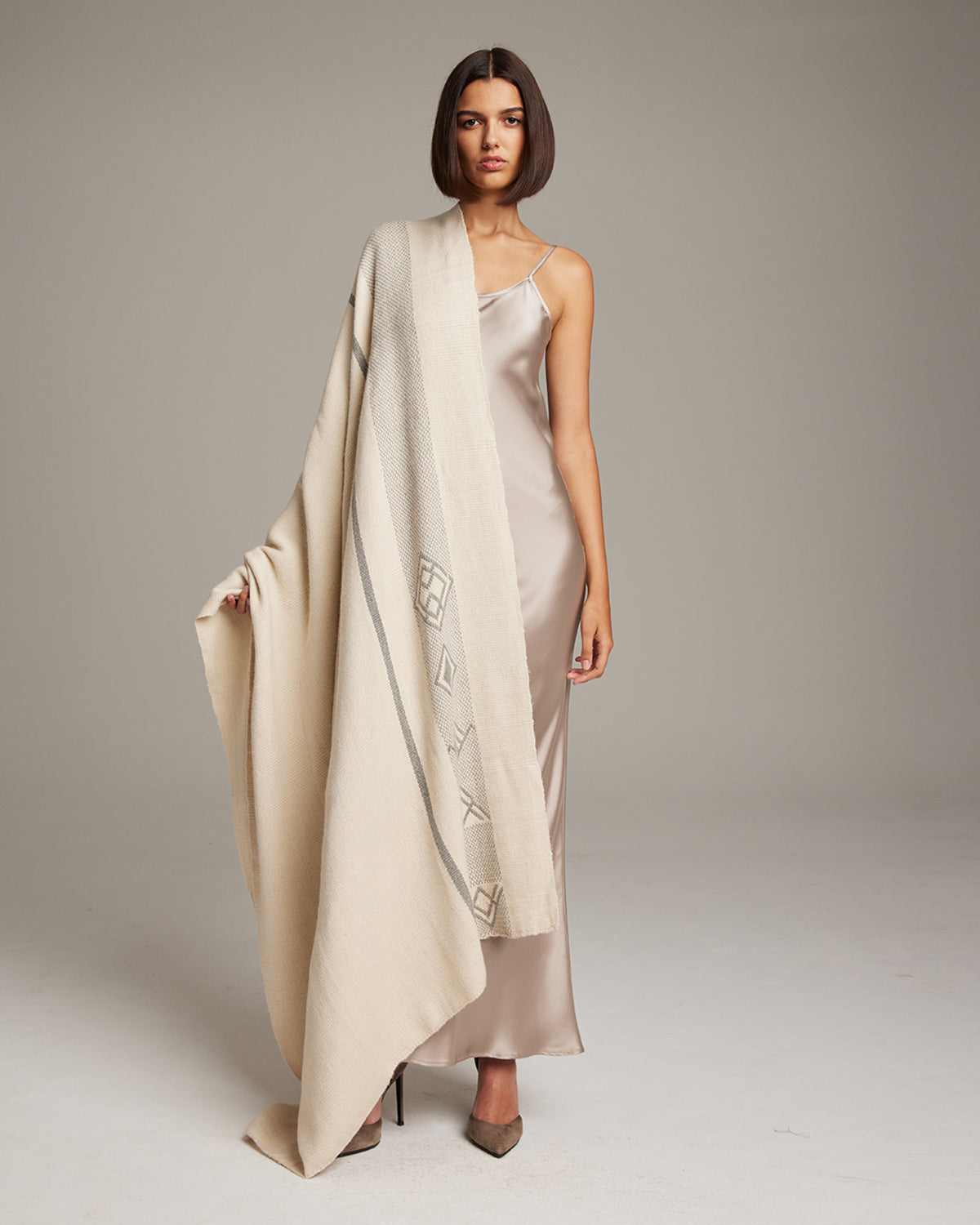 Model wearing a Wide Diagonal Alpaca Wrap in ivory, showcasing its design and texture.